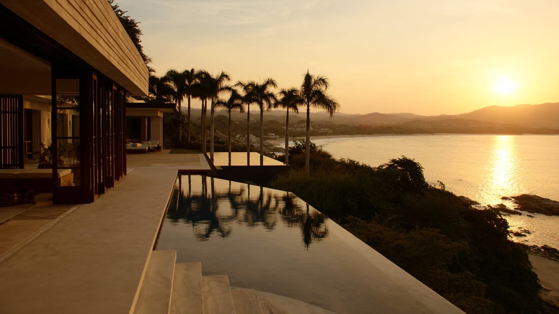Infinity-edge pool on an oceanfront terrace overlooking Banderas Bay at sunset
